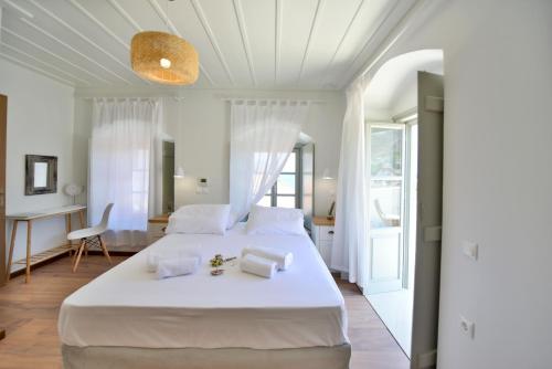 a bedroom with a large white bed and a desk at Onar Hydra in Hydra