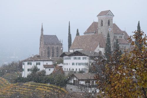 a group of buildings on a hill with a church at Moar am Ort in Schenna