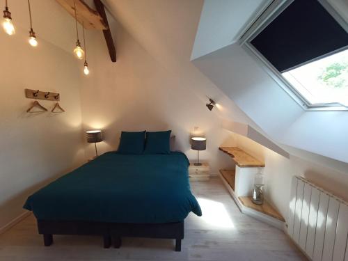 Un dormitorio con una cama verde en un ático en Chambre chez l'habitant Les Aubes du Vexin, en Nucourt