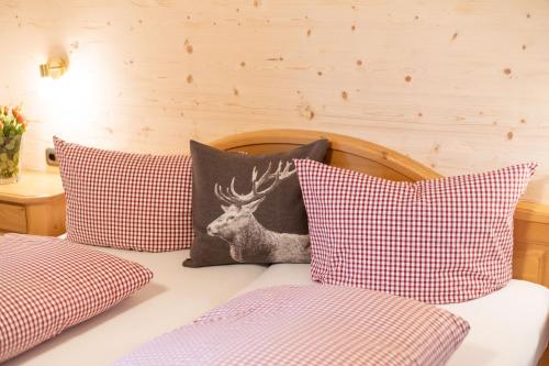 a bed with four pillows with a deer on it at Das Tannacker - Ferienwohnungen Hartmann in Fischen