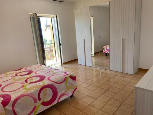 - une chambre avec un lit et un grand miroir dans l'établissement Casa Borrelli, à Cittadella del Capo