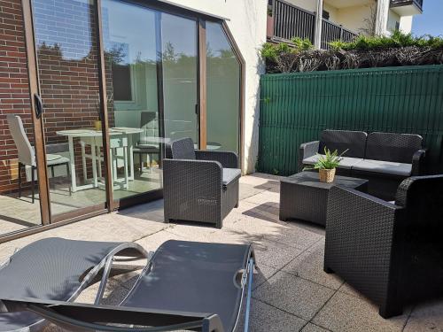a patio with chairs and tables and a table at Cabourg plage à 200m plage in Cabourg