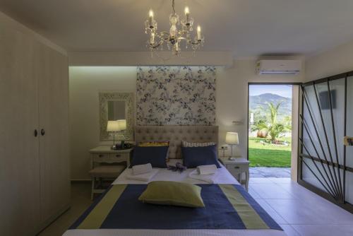 a bedroom with a bed and a desk and a chandelier at Annas Villa in Skala Potamias