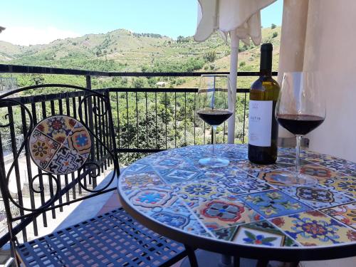 a table with two glasses and a bottle of wine at Etna Sicilian House in Linguaglossa