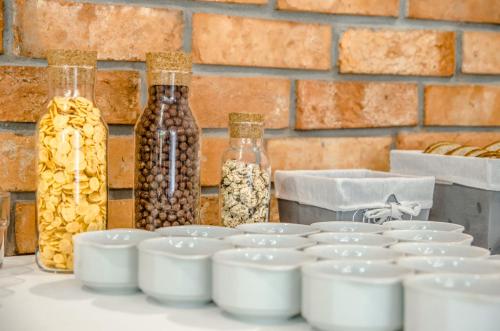 een tafel met witte kommen en flessen met eten bij Villa Chrobry in Mielno