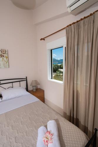 a bedroom with a bed and a window at Villa Nektaria in Nikiana