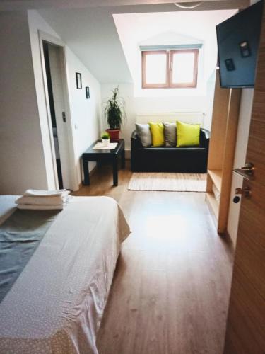 a living room with a bed and a couch at Central Guesthouse in Bucharest