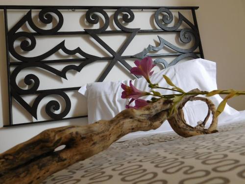 a branch with flowers on top of a bed at Albergo Alla Posta in Anduins