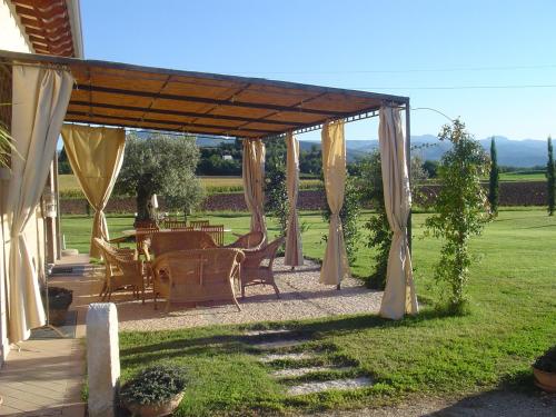 a pergola with a table and chairs in a yard at Agriturismo Sambuco in Pastrengo