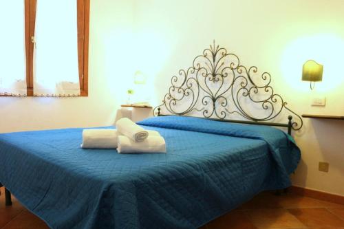 een slaapkamer met een blauw bed met 2 handdoeken erop bij L'isola incantata in Santa Teresa Gallura