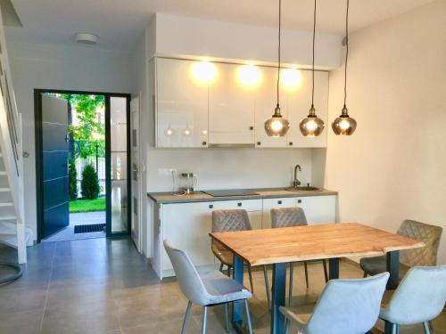 a kitchen and dining room with a wooden table and chairs at Pobierowo Dom z basenem Haus mit Schwimmbad in Pobierowo