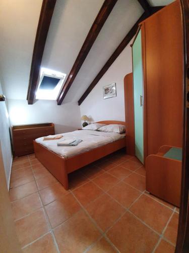 Dormitorio pequeño con cama en el ático en Kaprije Mistral Apartment, en Kaprije