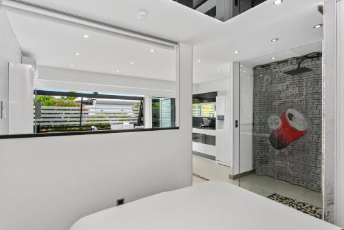 - une chambre avec une grande fenêtre et un mur en briques dans l'établissement Village Naturiste - La Villa Tentation Port Nature Luxe, au Cap d'Agde