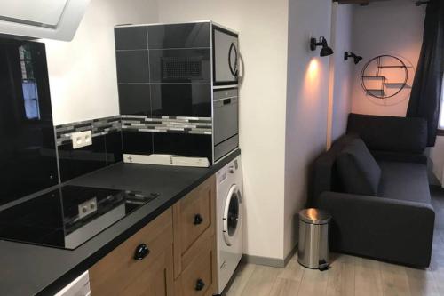 a living room with a microwave and a washing machine at Studio de la Tour des rondes - tout confort plein-centre in Lavaur