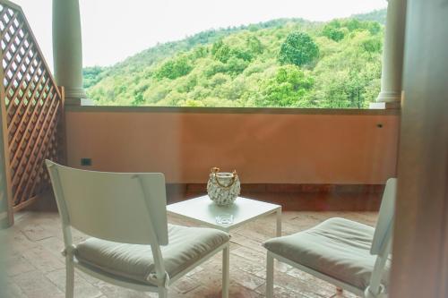 a balcony with two chairs and a table and a large window at Agriturismo Grammelot in Sarnico