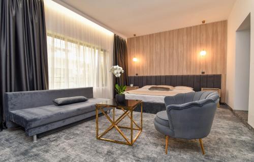 - une chambre avec un lit, un canapé et une chaise dans l'établissement Pensiunea Alfa, à Mamaia Nord – Năvodari
