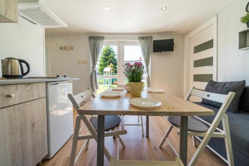 a kitchen and dining room with a table and chairs at Domki u Polki in Sławoszyno