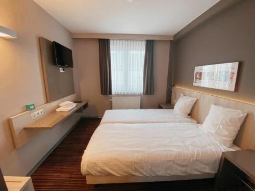 a hotel room with a bed and a television at Hotel les100ciels in Saint-Hubert