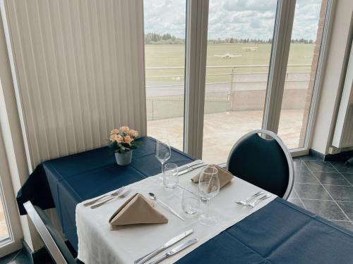 une table avec un chiffon de table bleu et des verres ainsi qu'une fenêtre dans l'établissement Hotel les100ciels, à Saint-Hubert