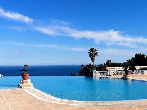 ein Schwimmbad mit dem Ozean im Hintergrund in der Unterkunft Duplex vue mer spendide, terrasse piscine jardins parking in Cannes