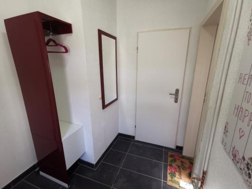 a bathroom with a white door and a black tile floor at Haus am Eichenwall, Fewo1, Residenz + Ferienwohnungen in Friedland