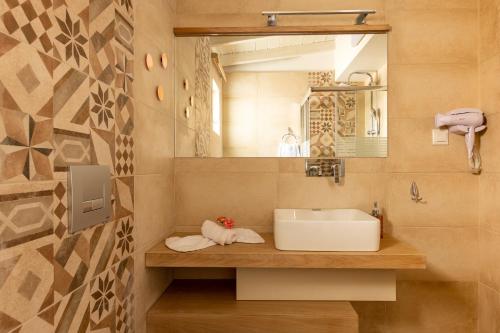ein Bad mit einem Waschbecken und einem Spiegel in der Unterkunft BOUTiE Lagom, a KalamataStay Property in Kalamata