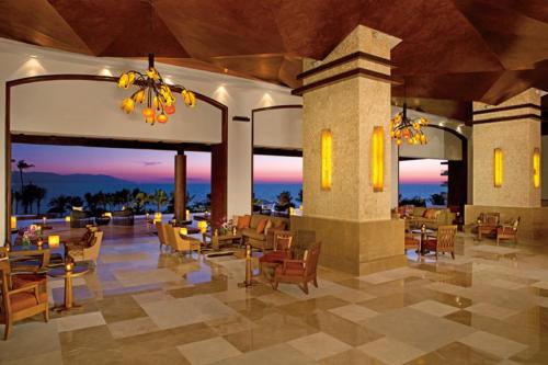 a lobby of a resort with tables and chairs at Dreams Vallarta Bay Resorts & Spa - All Inclusive in Puerto Vallarta
