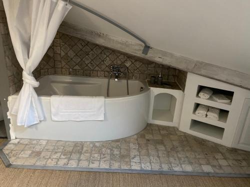 een badkamer met een wit bad en handdoeken bij Appartement cosy et moderne, proche Cité des Papes in Avignon