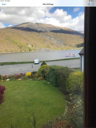 uma vista para um rio com um barco na água em Llanberis Snowdonia em Llanberis