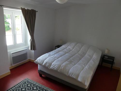 - une chambre avec un lit blanc et une fenêtre dans l'établissement Petit gite du Puy Lambert, à La Flocellière