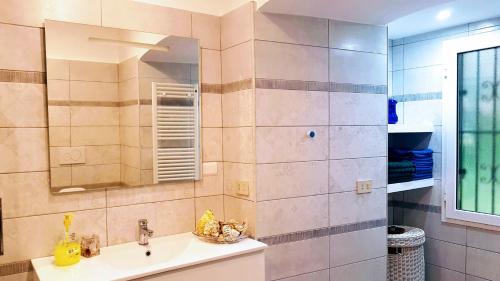 bagno con lavandino e specchio di Appuntamento Al porto a Savona