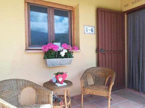 a patio with two chairs and a table and a window at El Mirador del Gato I y II in Mesegar de Corneja