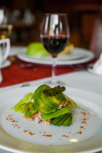 a plate of food and a glass of wine on a table at Hotel Diego de Almagro Punta Arenas in Punta Arenas