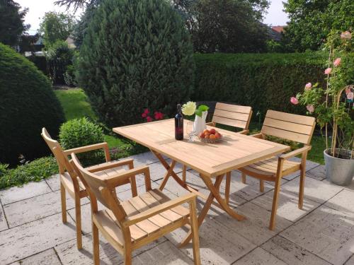a wooden table and chairs with a bowl of fruit on it at HAuszeit - Zeit für dich - Zeit am See in Neufeld an der Leitha