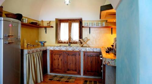 a kitchen with a sink and a refrigerator at Dammusi di Sofia in Pantelleria