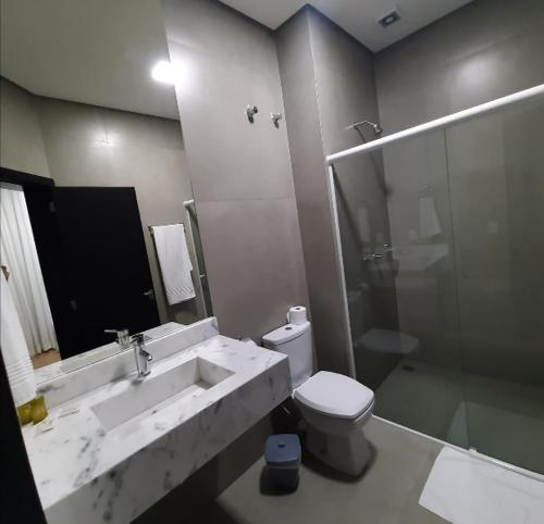 a bathroom with a sink and a toilet and a shower at Hotel Alvorada - Trindade do Sul in Trindade