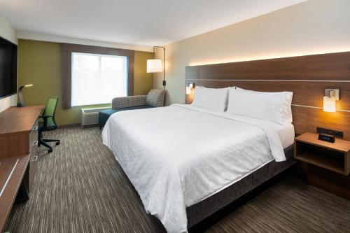 a hotel room with a large bed and a desk at Holiday Inn Express & Suites Halifax Airport by IHG in Enfield