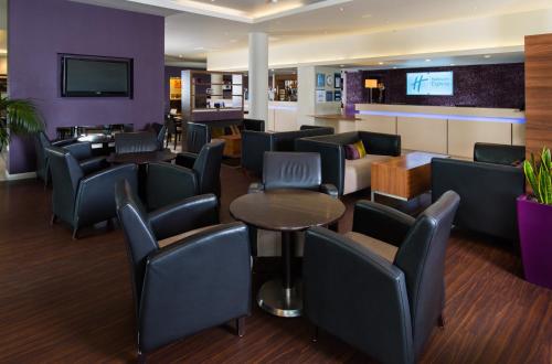 
a living room filled with tables and chairs at Holiday Inn Express London Greenwich, an IHG Hotel in London
