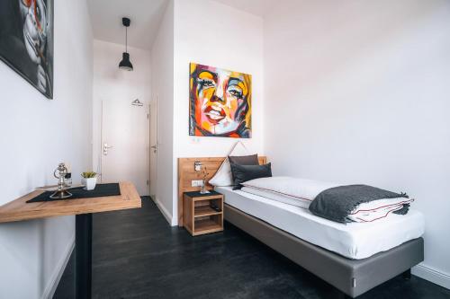 1 dormitorio con 1 cama con una pintura en la pared en Sleep Point en Bremen