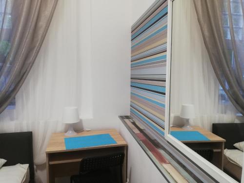 a mirror in a room with two tables and chairs at Lorf Hostel&Coffee in Kraków