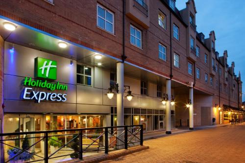
a large building with a neon sign on the side of it at Holiday Inn Express London-Hammersmith, an IHG Hotel in London
