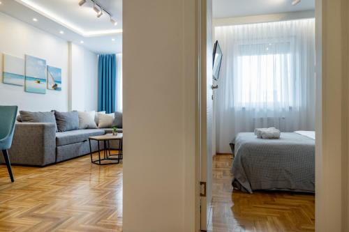 a living room with a bed and a couch at Bianca Apartment in Novi Sad