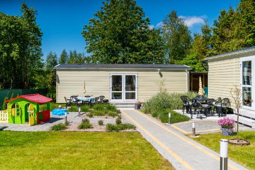 a small house with a table and a playground at Domki u Polki in Sławoszyno