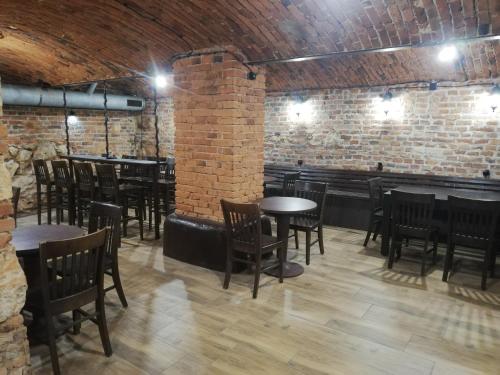 un restaurant avec des tables et des chaises et un mur en briques dans l'établissement Lorf Hostel&Coffee, à Cracovie