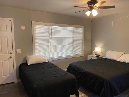 a bedroom with two beds and a ceiling fan at Dahl's Motel in Oroville