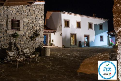 a building with chairs in front of it at night at Puial de l Douro in Miranda do Douro