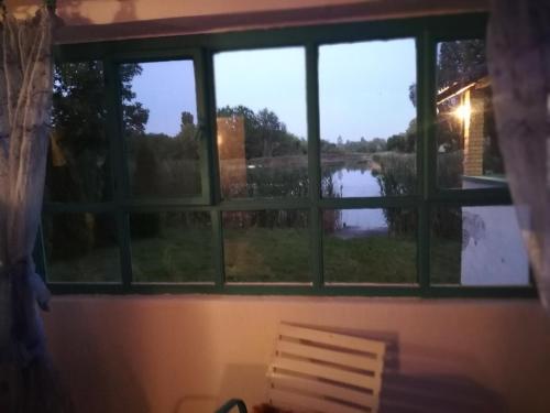 a window with a view of a lake seen through it at ZEN - VIKENDICA in Bezdan