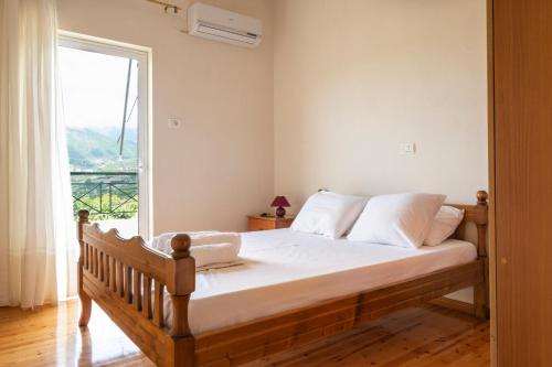 um quarto com uma cama e uma janela grande em Janakis Apartments em Himare