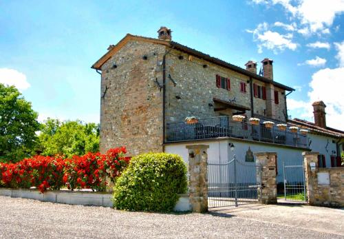 un vecchio edificio con fiori rossi di fronte di Casa Donella B&B a Gricignano