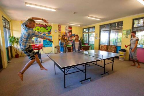 eine Gruppe von Menschen, die Tischtennis spielen in der Unterkunft Coolangatta YHA Backpackers in Gold Coast